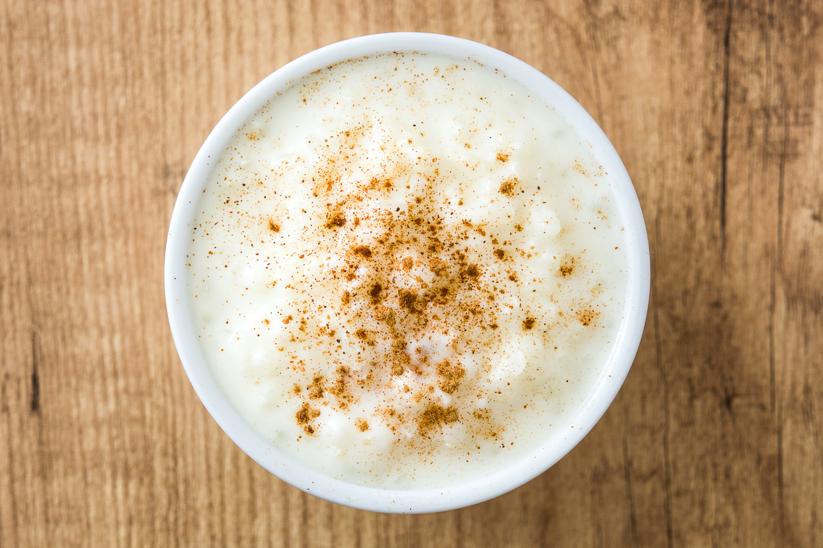 Arroz con leche. Rice pudding with cinnamon on wooden background